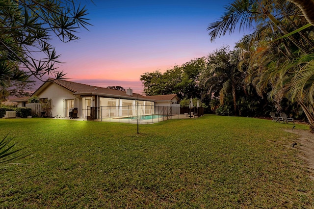 yard at dusk featuring a fenced in pool and fence