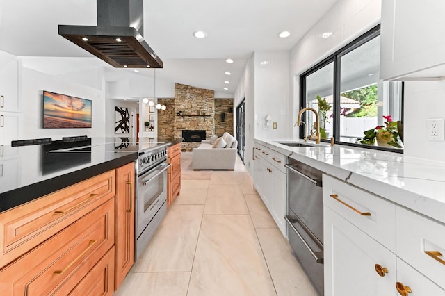 kitchen featuring a sink, open floor plan, extractor fan, stainless steel range, and a fireplace