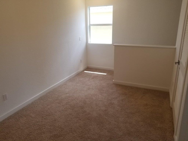 unfurnished room with carpet flooring and baseboards