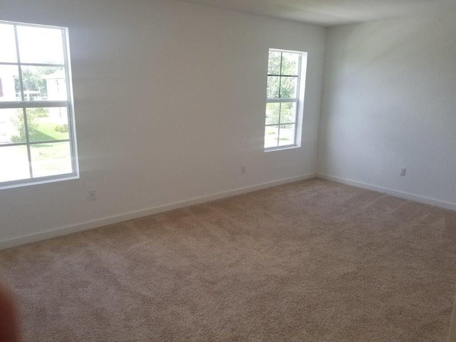 empty room with light carpet and baseboards