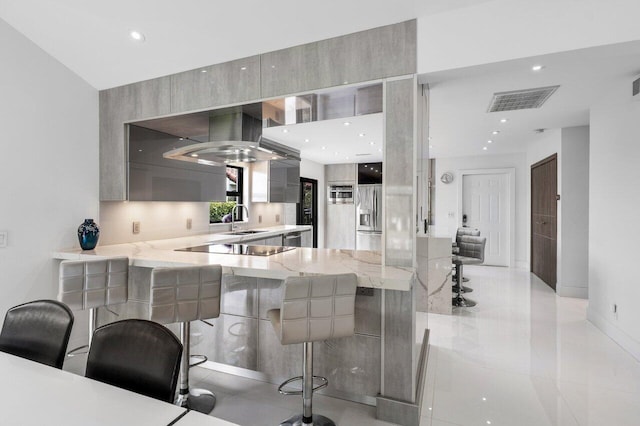 21481 Cypress Hammock Dr Unit 31B, Boca Raton, FL 33428 - kitchen with a breakfast bar area, visible vents, modern cabinets, light stone countertops, and a sink