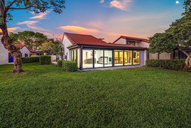 21481 Cypress Hammock Dr Unit 31B, Boca Raton, FL 33428 - rear view of property with a sunroom, stucco siding, a yard, and a tile roof