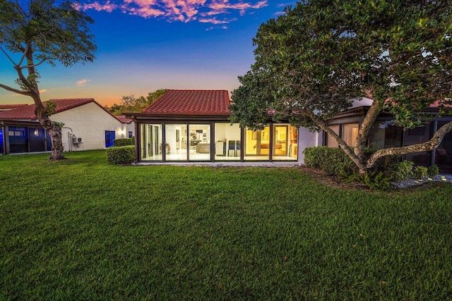 21481 Cypress Hammock Dr Unit 31B, Boca Raton, FL 33428 - rear view of property featuring a yard, stucco siding, a sunroom, and a tile roof