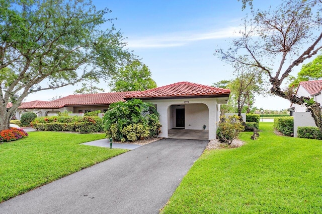 21481 Cypress Hammock Dr Unit 31B, Boca Raton, FL 33428 - mediterranean / spanish house featuring a front lawn, stucco siding, a tiled roof, and driveway