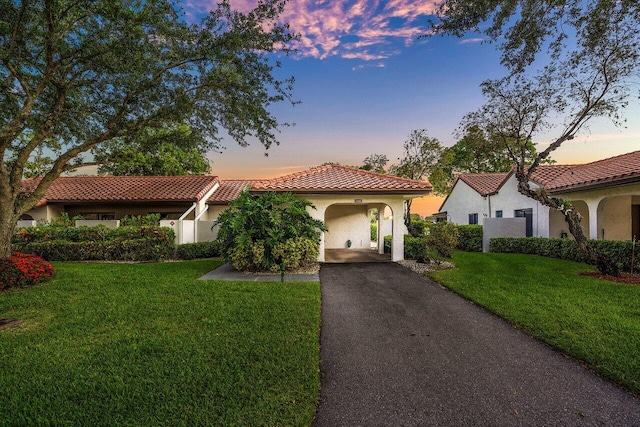 21481 Cypress Hammock Dr Unit 31B, Boca Raton, FL 33428 - mediterranean / spanish-style home with a front lawn, aphalt driveway, stucco siding, a carport, and a tiled roof