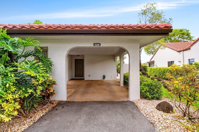 21481 Cypress Hammock Dr Unit 31B, Boca Raton, FL 33428 - property entrance with a porch, aphalt driveway, stucco siding, and a tile roof