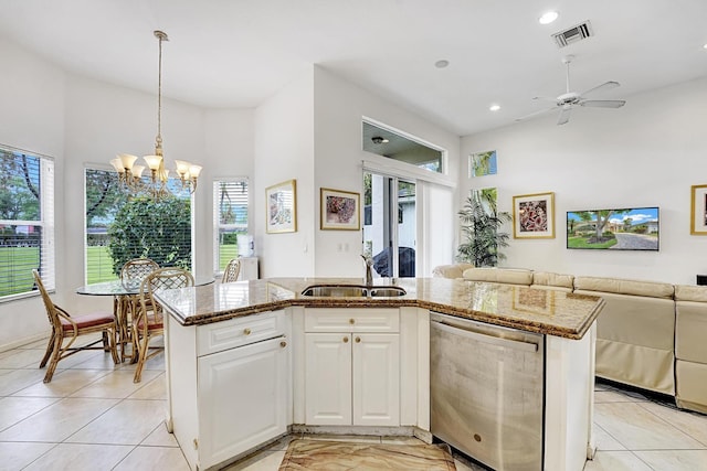 kitchen featuring stainless steel dishwasher, a sink, open floor plan, plenty of natural light, and recessed lighting