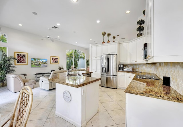 kitchen with stainless steel refrigerator with ice dispenser, a sink, black electric stovetop, recessed lighting, and tasteful backsplash