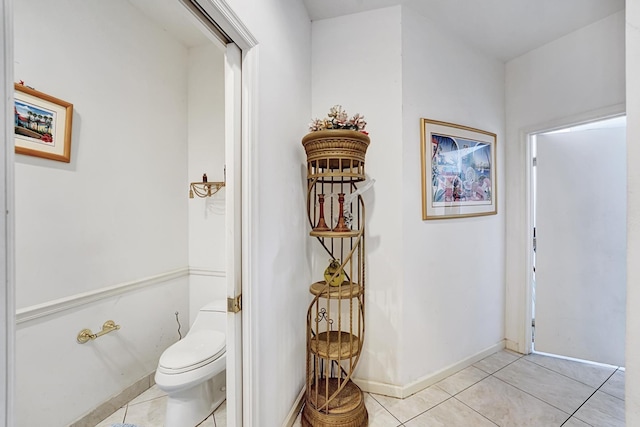 bathroom with tile patterned floors, toilet, and baseboards