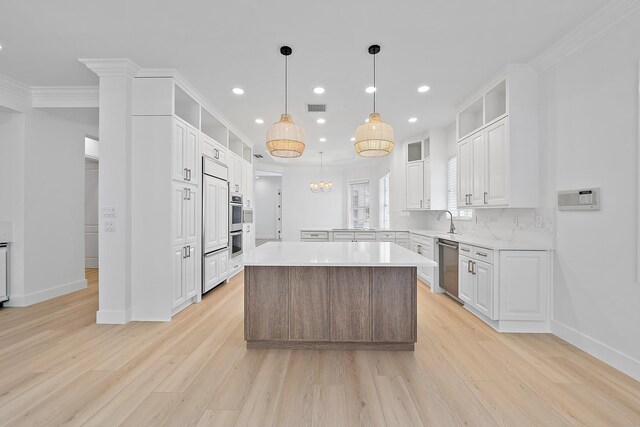 17065 Bay St, Jupiter, FL 33477 - kitchen with ornamental molding, light countertops, white cabinets, visible vents, and stainless steel dishwasher