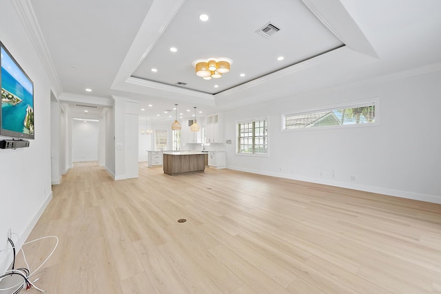 17065 Bay St, Jupiter, FL 33477 - unfurnished living room with a tray ceiling, light wood-type flooring, ornamental molding, visible vents, and baseboards