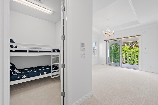 17065 Bay St, Jupiter, FL 33477 - bedroom featuring a chandelier, access to exterior, carpet flooring, a raised ceiling, and baseboards