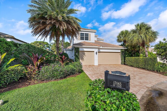 17065 Bay St, Jupiter, FL 33477 - view of front of property featuring a tiled roof, stucco siding, and decorative driveway