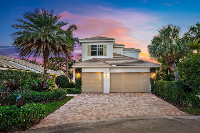 17065 Bay St, Jupiter, FL 33477 - view of front of property featuring stucco siding, a tile roof, and decorative driveway