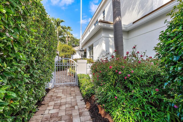 17065 Bay St, Jupiter, FL 33477 - view of property exterior with stucco siding, fence, and a gate