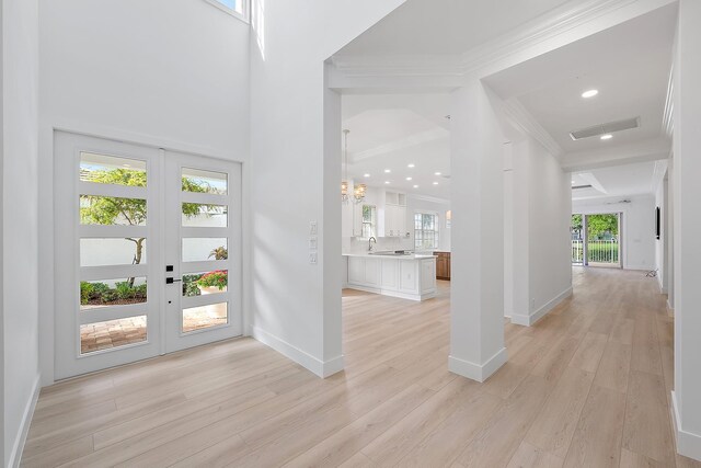 17065 Bay St, Jupiter, FL 33477 - foyer entrance with visible vents, baseboards, light wood-type flooring, a chandelier, and crown molding