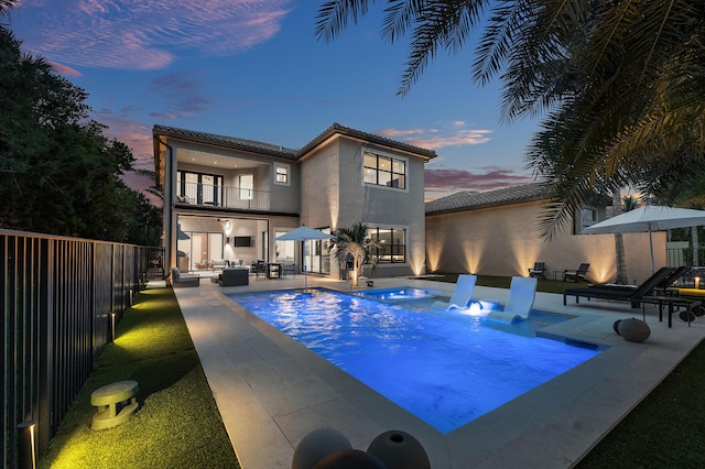 16491 Gateway Bridge Dr, Delray Beach, FL 33446 - pool at dusk with a fenced backyard, a patio, outdoor lounge area, and a pool with connected hot tub