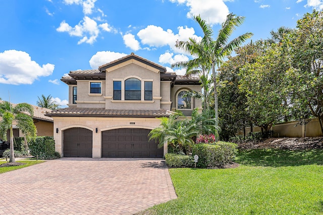 16491 Gateway Bridge Dr, Delray Beach, FL 33446 - mediterranean / spanish-style house with decorative driveway, an attached garage, a front yard, a tile roof, and stucco siding