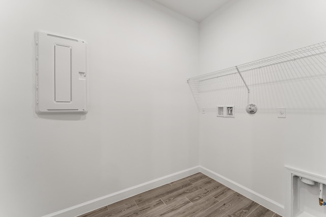 clothes washing area featuring wood finished floors, hookup for an electric dryer, baseboards, laundry area, and washer hookup