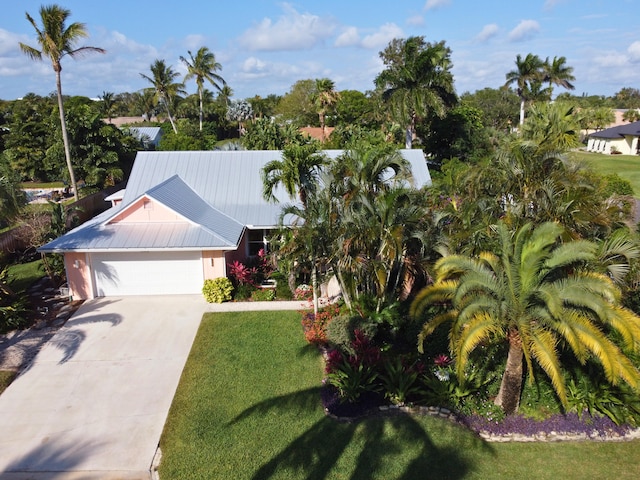 9208 SE Gettysburg Ct, Hobe Sound, FL 33455 - view of front facade with an attached garage, a front yard, driveway, and metal roof