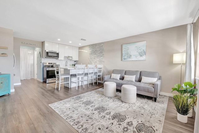 2081 NE 56th St Unit 207, Fort Lauderdale, FL 33308 - living room featuring light wood finished floors, baseboards, and recessed lighting