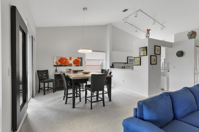 9927 Seacrest Cir Unit 202, Boynton Beach, FL 33437 - carpeted dining room with high vaulted ceiling, baseboards, and rail lighting
