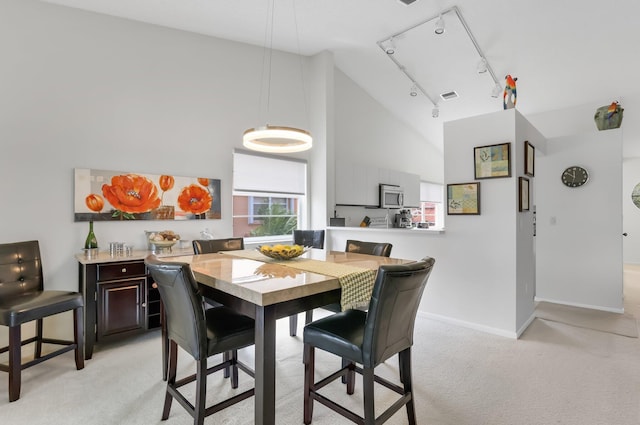 9927 Seacrest Cir Unit 202, Boynton Beach, FL 33437 - dining space with visible vents, baseboards, high vaulted ceiling, light colored carpet, and rail lighting