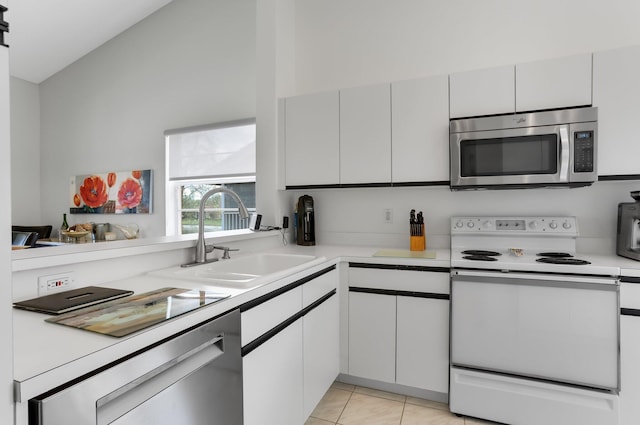 9927 Seacrest Cir Unit 202, Boynton Beach, FL 33437 - kitchen with lofted ceiling, light tile patterned flooring, light countertops, a sink, and appliances with stainless steel finishes