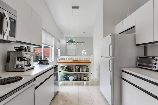 9927 Seacrest Cir Unit 202, Boynton Beach, FL 33437 - kitchen featuring a toaster, light countertops, stainless steel microwave, freestanding refrigerator, and white cabinetry