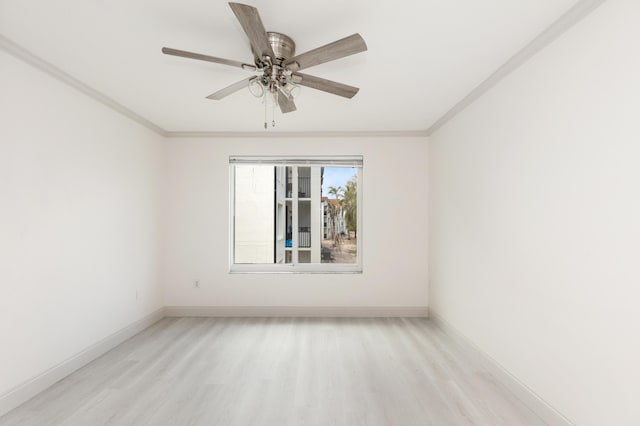 spare room featuring baseboards, ornamental molding, and light wood-style flooring