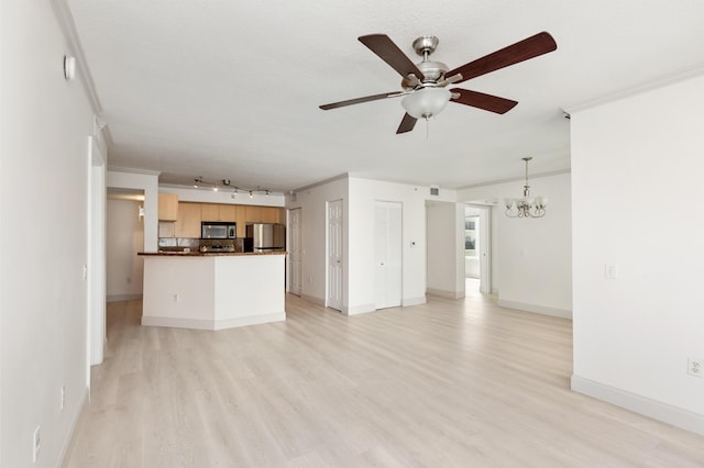 unfurnished living room with light wood-style flooring, ornamental molding, ceiling fan with notable chandelier, and baseboards
