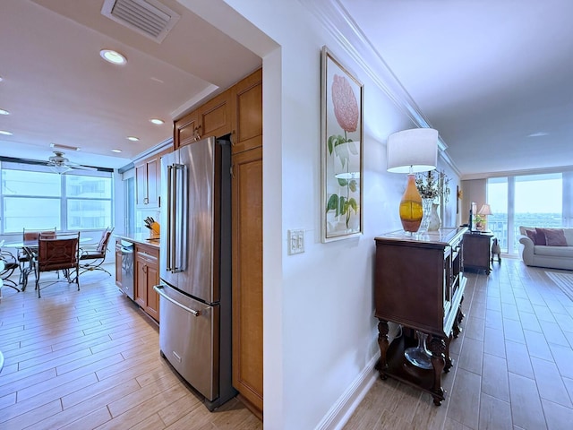 kitchen featuring visible vents, stainless steel appliances, ornamental molding, and brown cabinetry