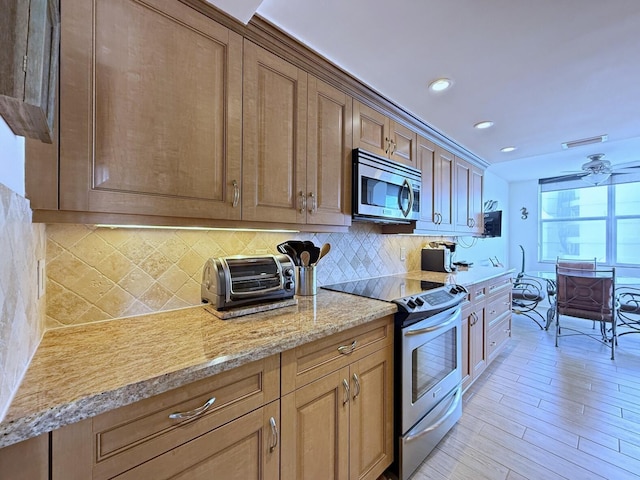 kitchen featuring backsplash, visible vents, appliances with stainless steel finishes, and light wood-type flooring