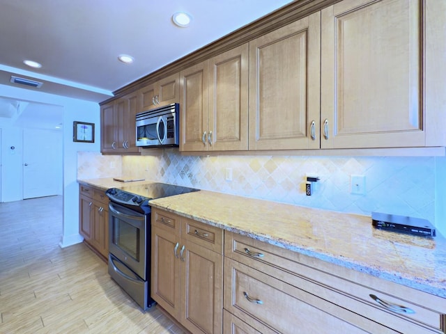kitchen with appliances with stainless steel finishes, visible vents, decorative backsplash, and light stone counters