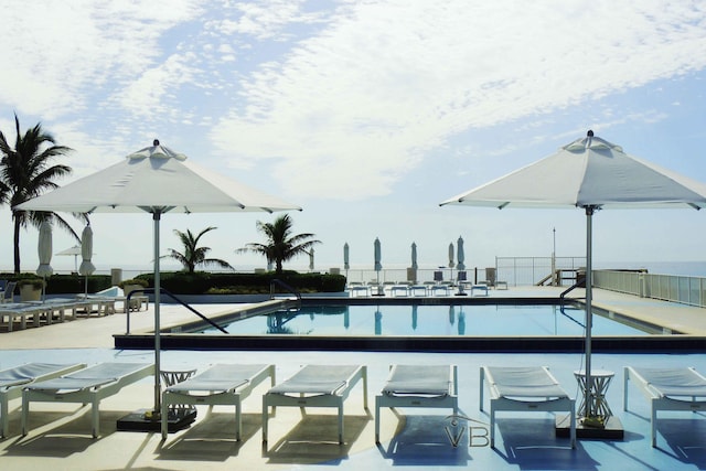 community pool with fence and a patio area
