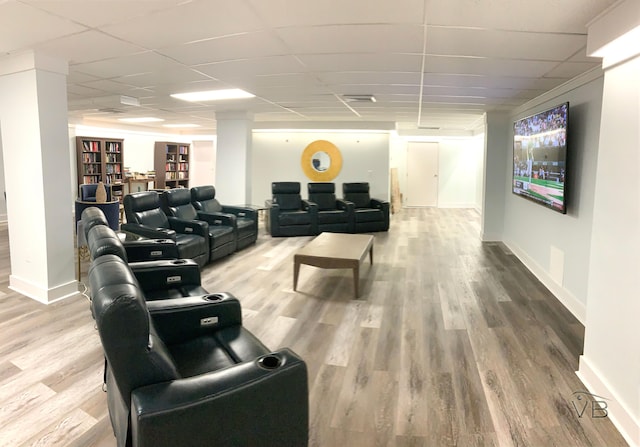 interior space with a paneled ceiling, visible vents, wood finished floors, and baseboards
