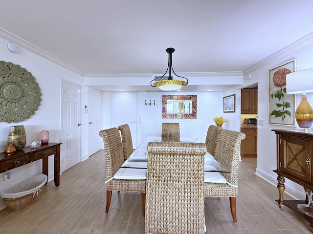dining area with crown molding, light wood finished floors, and baseboards