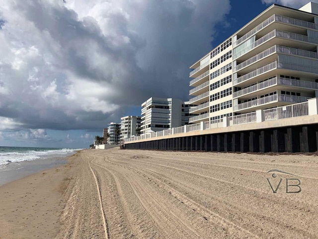 view of building exterior featuring a beach view and a water view