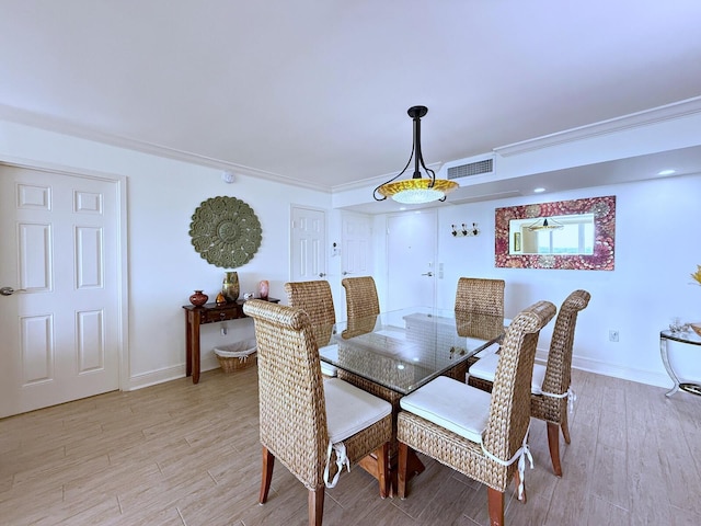 dining area featuring light wood-style floors, visible vents, and baseboards