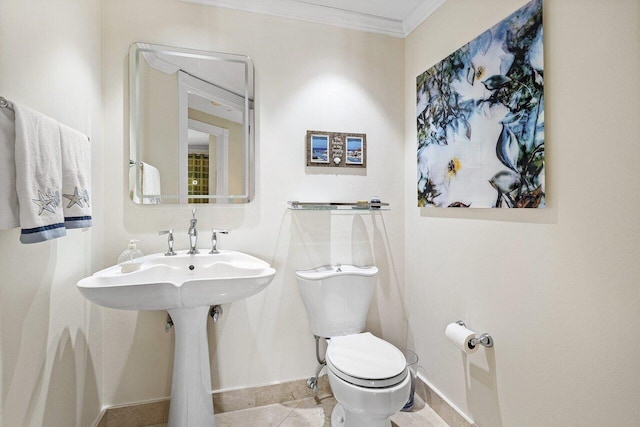 bathroom featuring baseboards, ornamental molding, and toilet
