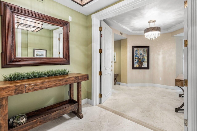 hall featuring a chandelier, baseboards, and visible vents