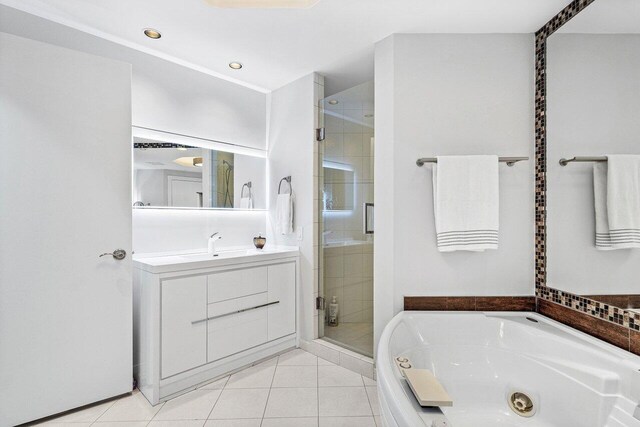 bathroom featuring a stall shower, vanity, a tub with jets, and tile patterned flooring
