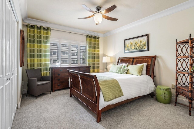 bedroom featuring ornamental molding, ceiling fan, and light colored carpet