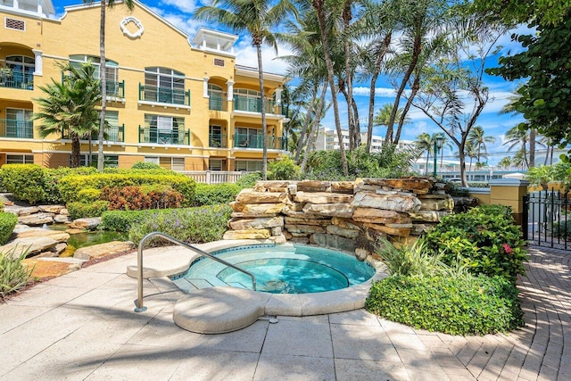view of swimming pool with cooling unit and a community hot tub