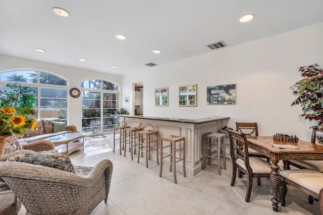 dining space with a bar, recessed lighting, light tile patterned flooring, and visible vents