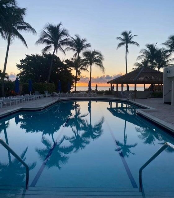 3400 S Ocean Blvd Unit 3H, Highland Beach, FL 33487 - pool at dusk featuring a gazebo, a community pool, and a patio