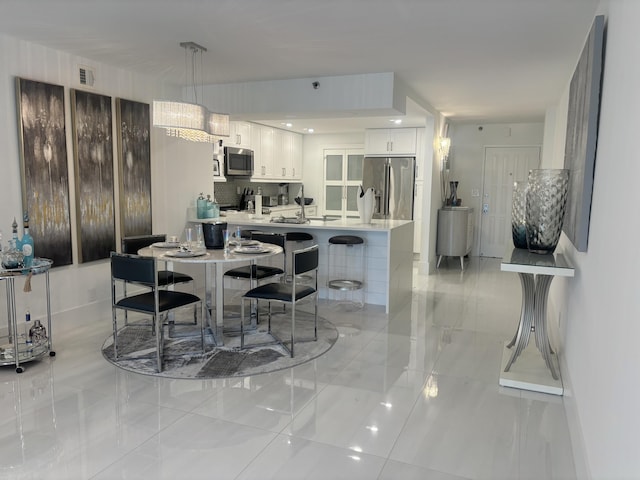 3400 S Ocean Blvd Unit 3H, Highland Beach, FL 33487 - kitchen featuring appliances with stainless steel finishes, white cabinetry, a peninsula, light countertops, and a breakfast bar