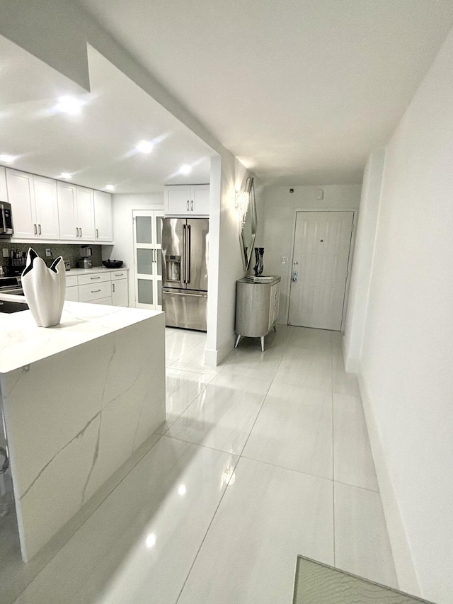 3400 S Ocean Blvd Unit 3H, Highland Beach, FL 33487 - kitchen featuring stainless steel appliances, white cabinets, light stone counters, decorative backsplash, and recessed lighting