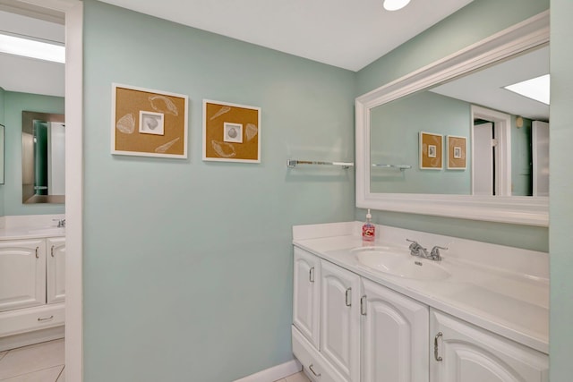 2400 S Ocean Dr Unit 1216, Fort Pierce, FL 34949 - bathroom featuring tile patterned floors, two vanities, a sink, and baseboards