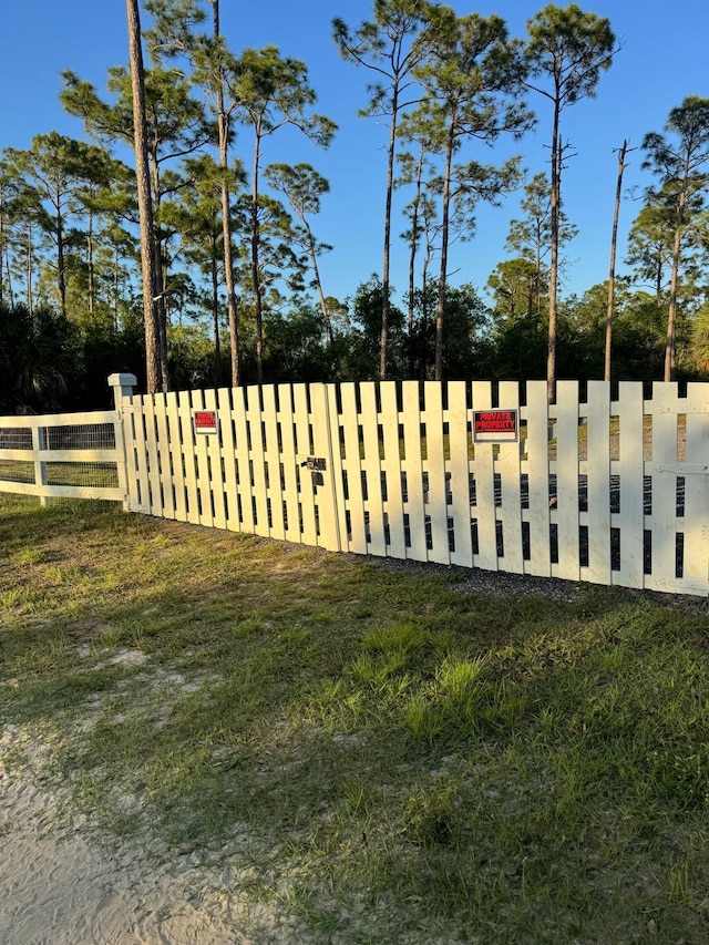 view of gate featuring a yard and fence